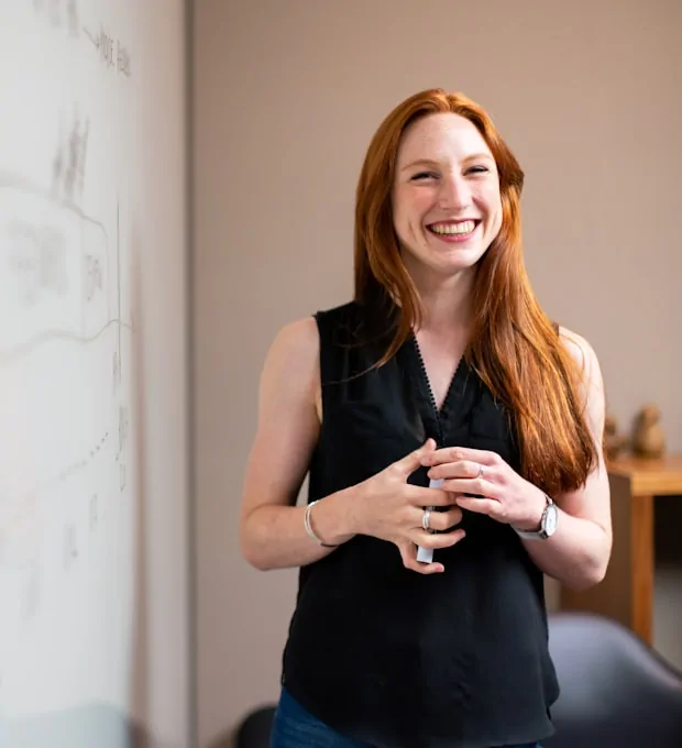 Smiling woman presenting at a whiteboard
